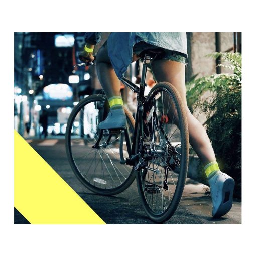 Jól látható, neon színű, önzáródó fényvisszaverő karpánt csuklón viselve sötétben.