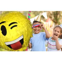 Színes Smiley pinyáta édességekkel töltve egy vidám születésnapi bulin.