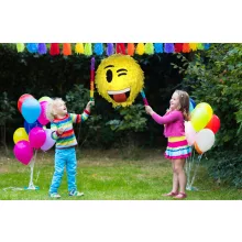 Színes Smiley pinyáta édességekkel töltve egy vidám születésnapi bulin.