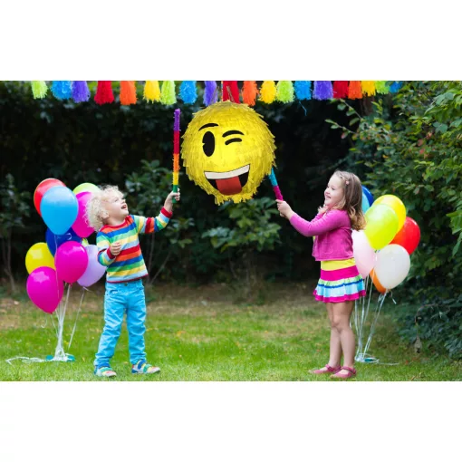 Színes Smiley pinyáta édességekkel töltve egy vidám születésnapi bulin.