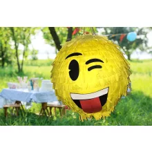 Színes Smiley pinyáta édességekkel töltve egy vidám születésnapi bulin.