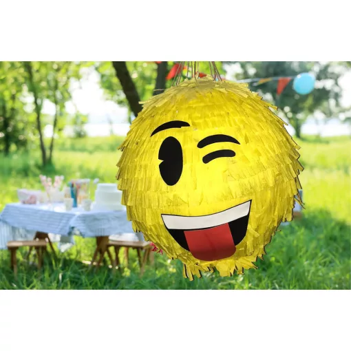 Színes Smiley pinyáta édességekkel töltve egy vidám születésnapi bulin.