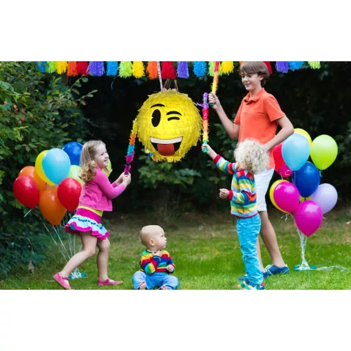 Színes Smiley pinyáta édességekkel töltve egy vidám születésnapi bulin.